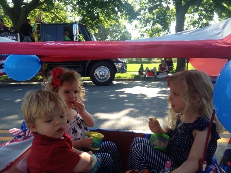 Mason family toddlers sharing snacks at the Independence Day parade